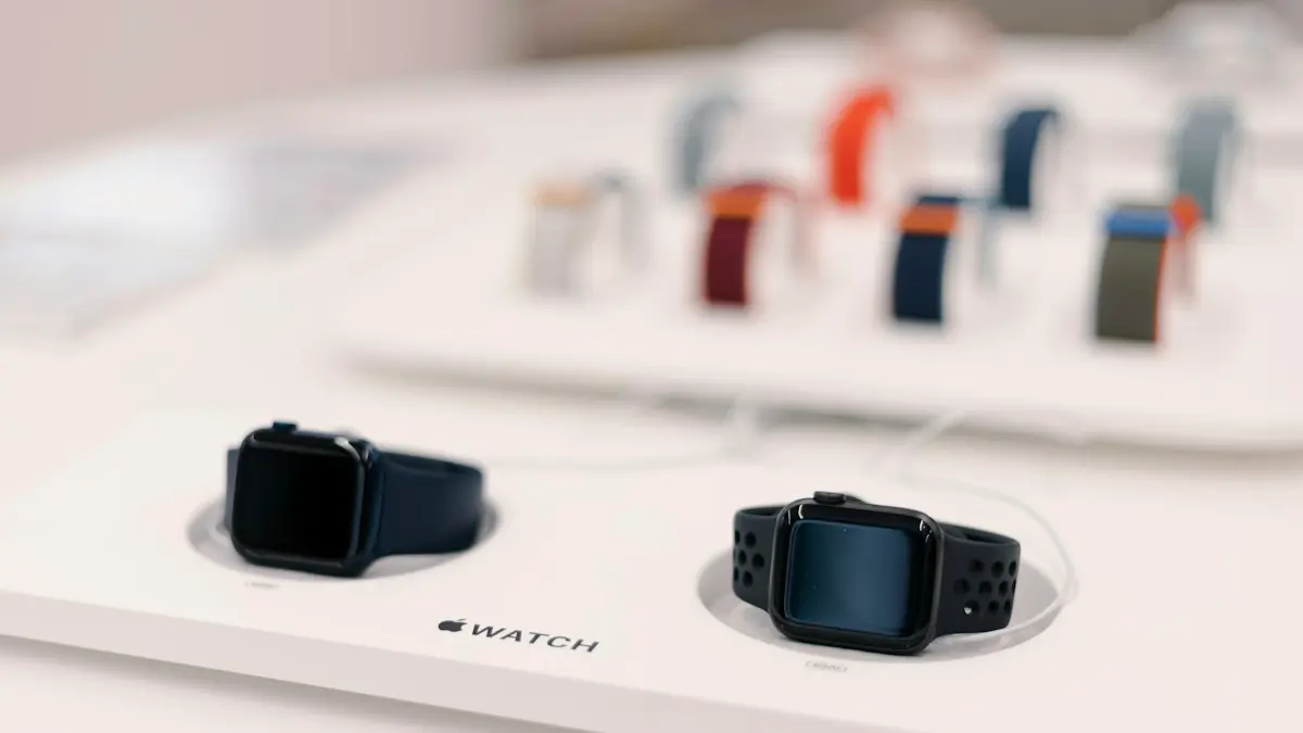 A couple of smart watches sitting on top of a table