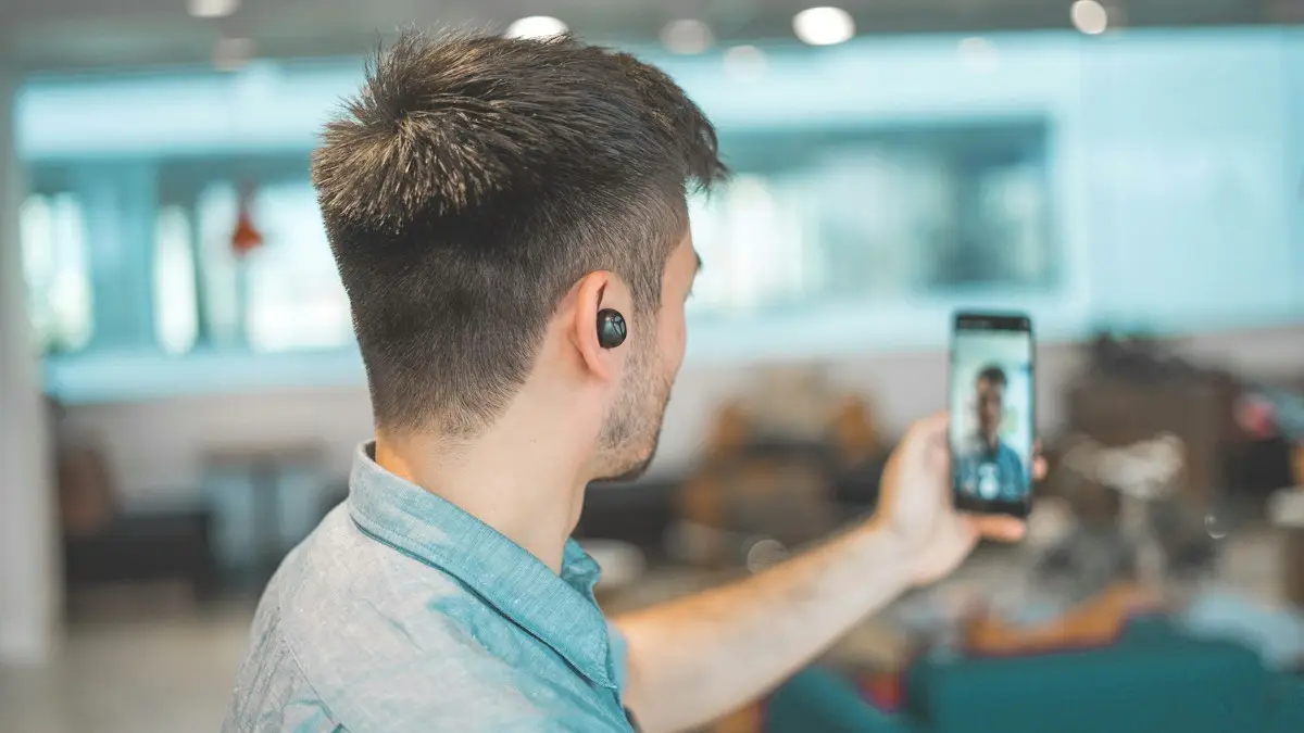Shallow focus photo of man in gray collared top taking selfie