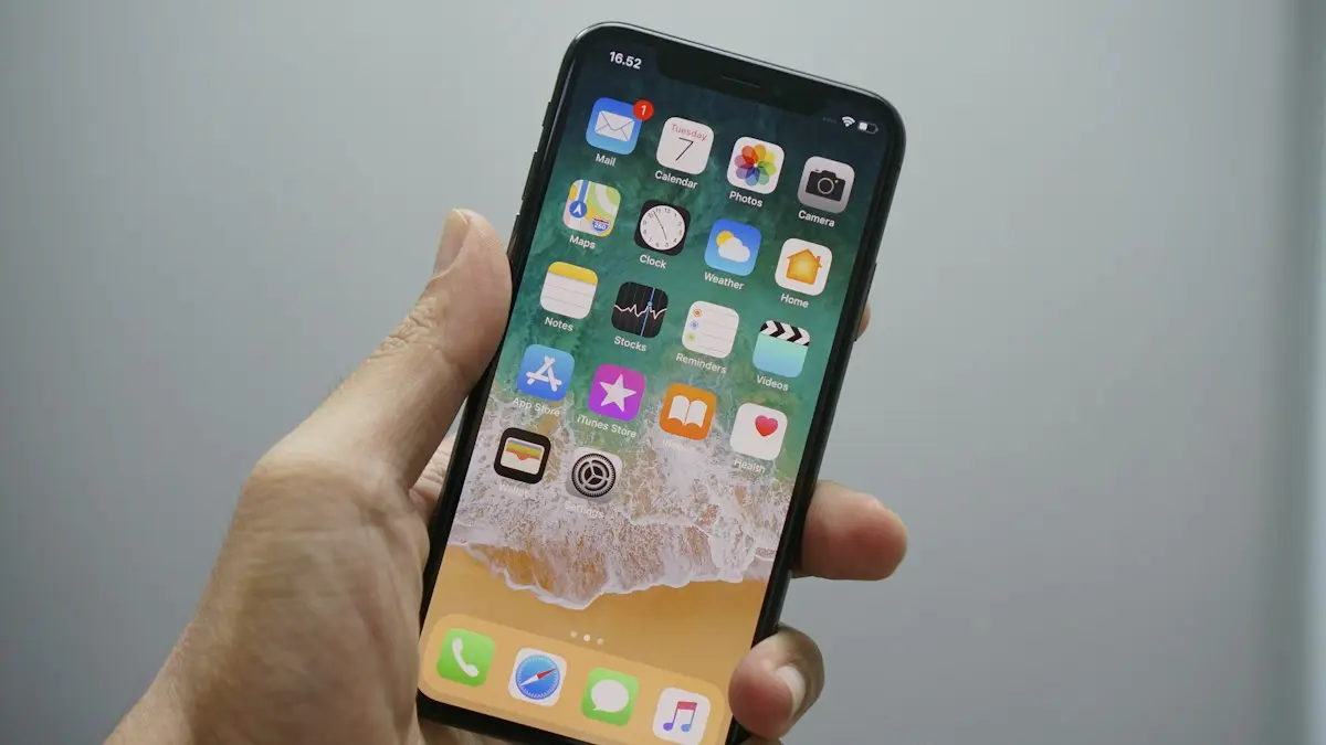 A hand holding a smartphone displaying a home screen with various app icons