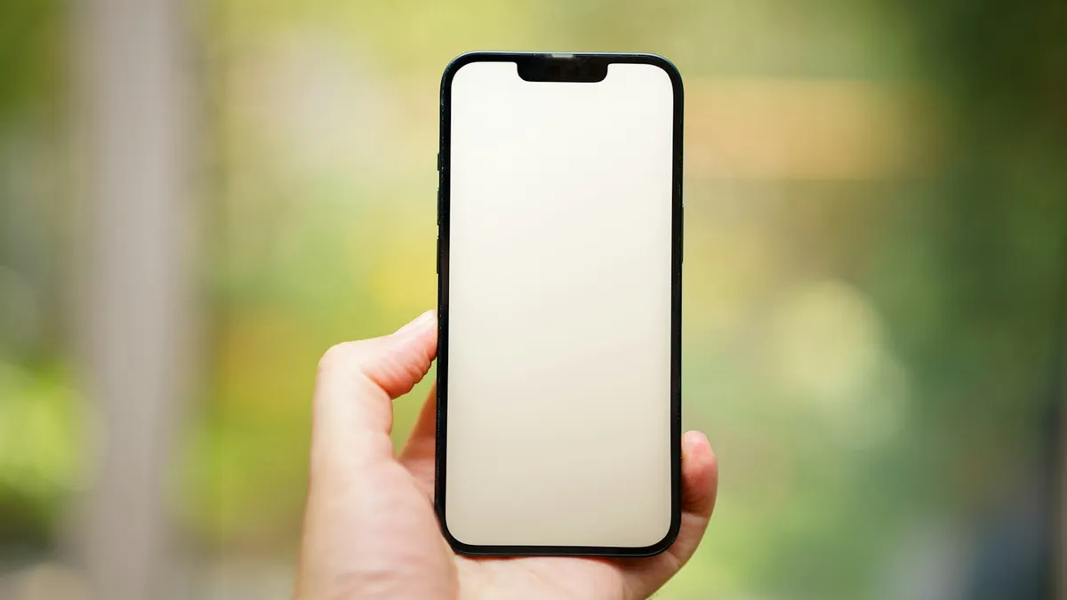 A person holding a cell phone in their hand