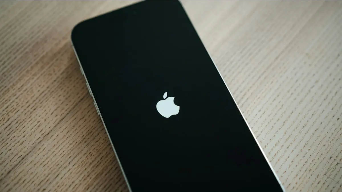 A black iPhone sitting on top of a wooden table