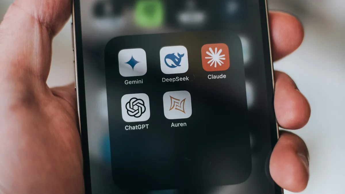 A hand holding a phone with AI application icons