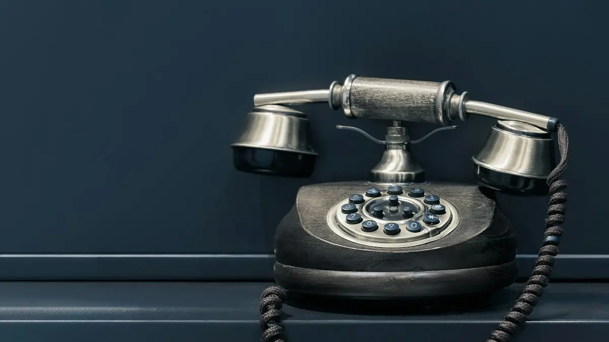 Black and brown rotary phone near gray wall