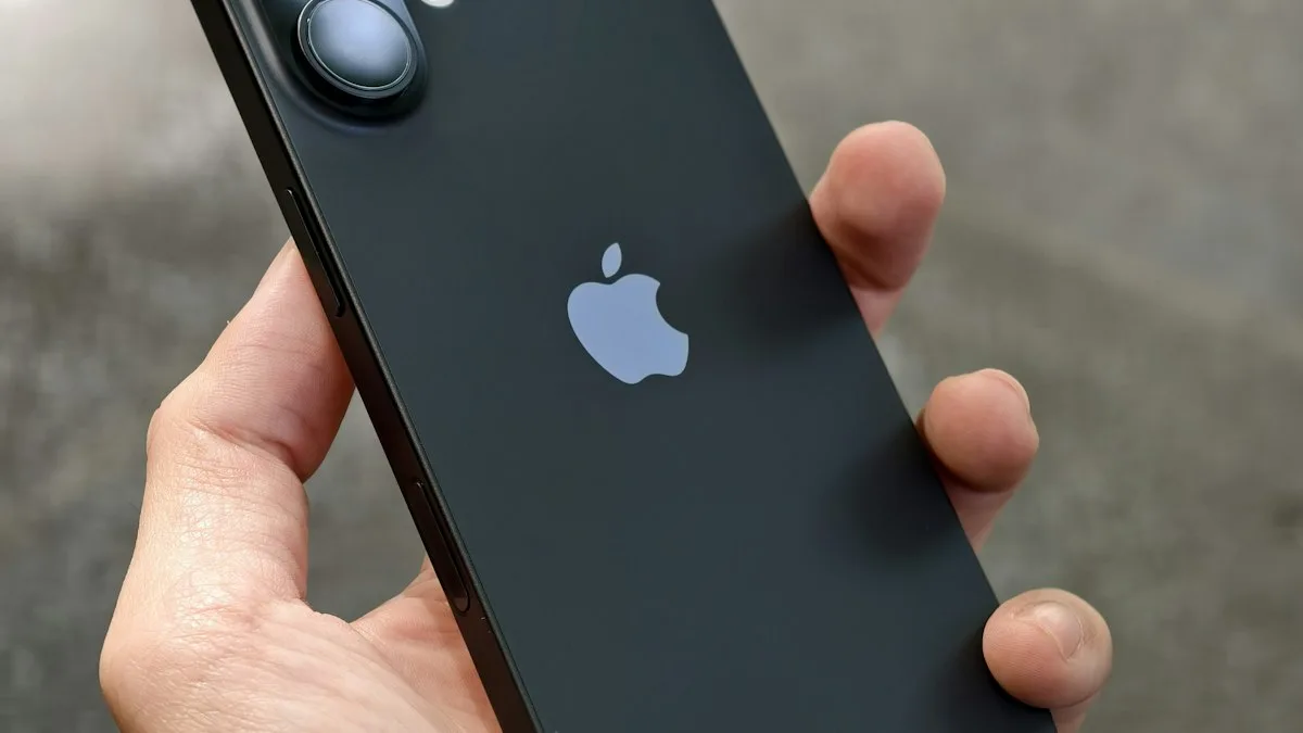A person holding a black iPhone in one hand