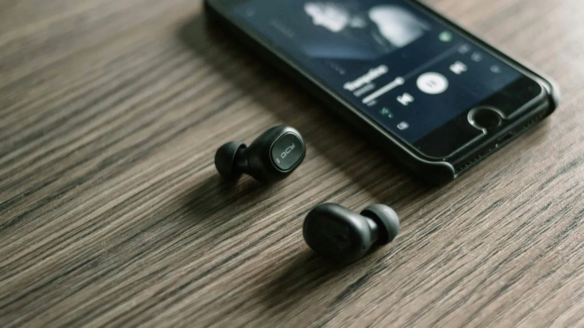 A pair of earphones beside a phone
