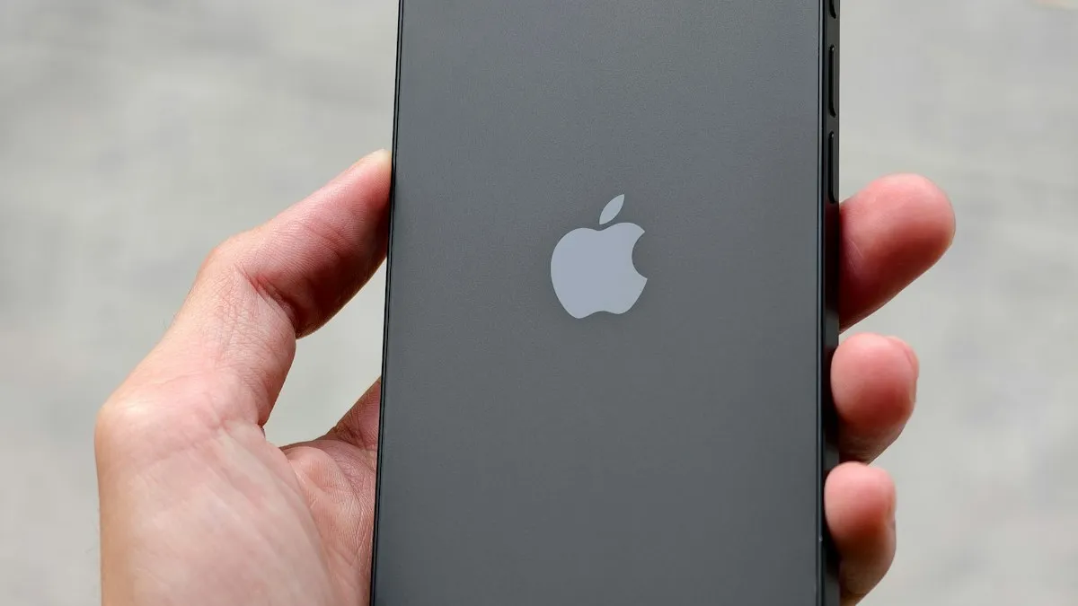 A hand holding a black iPhone