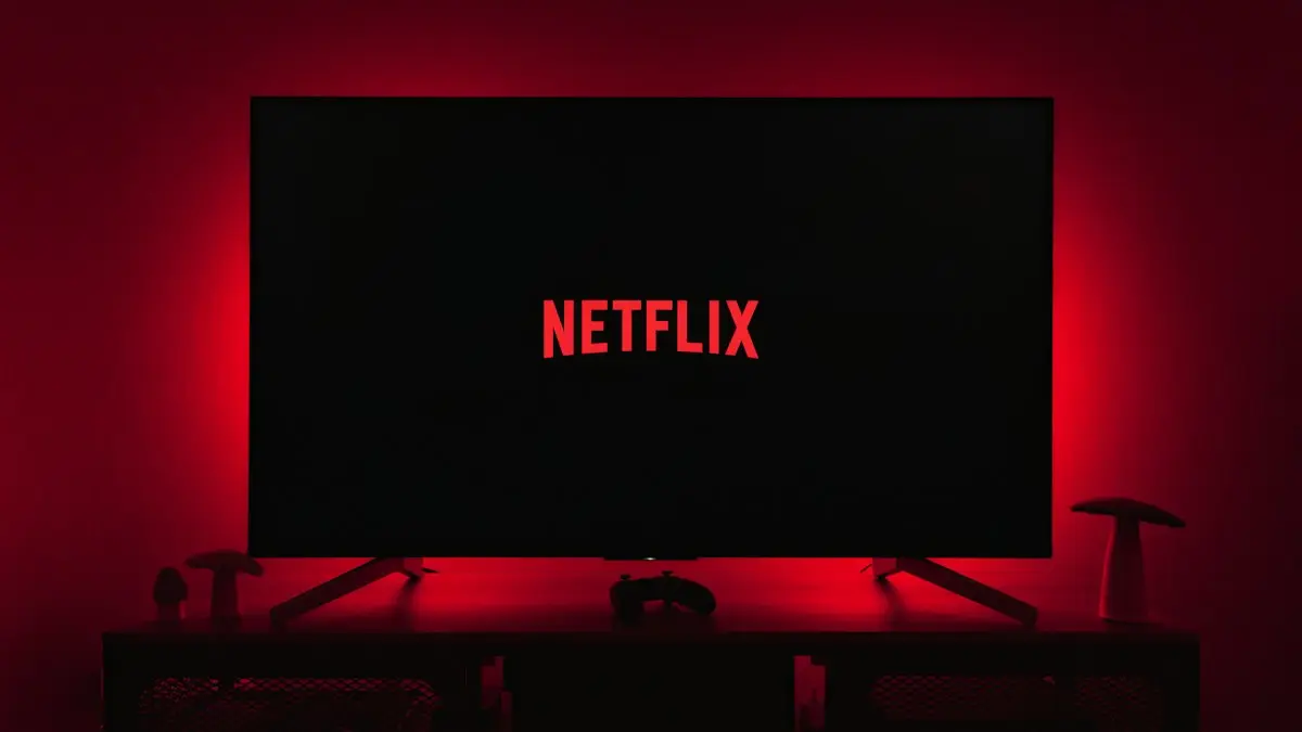 A television with the netflix logo lit up in the dark