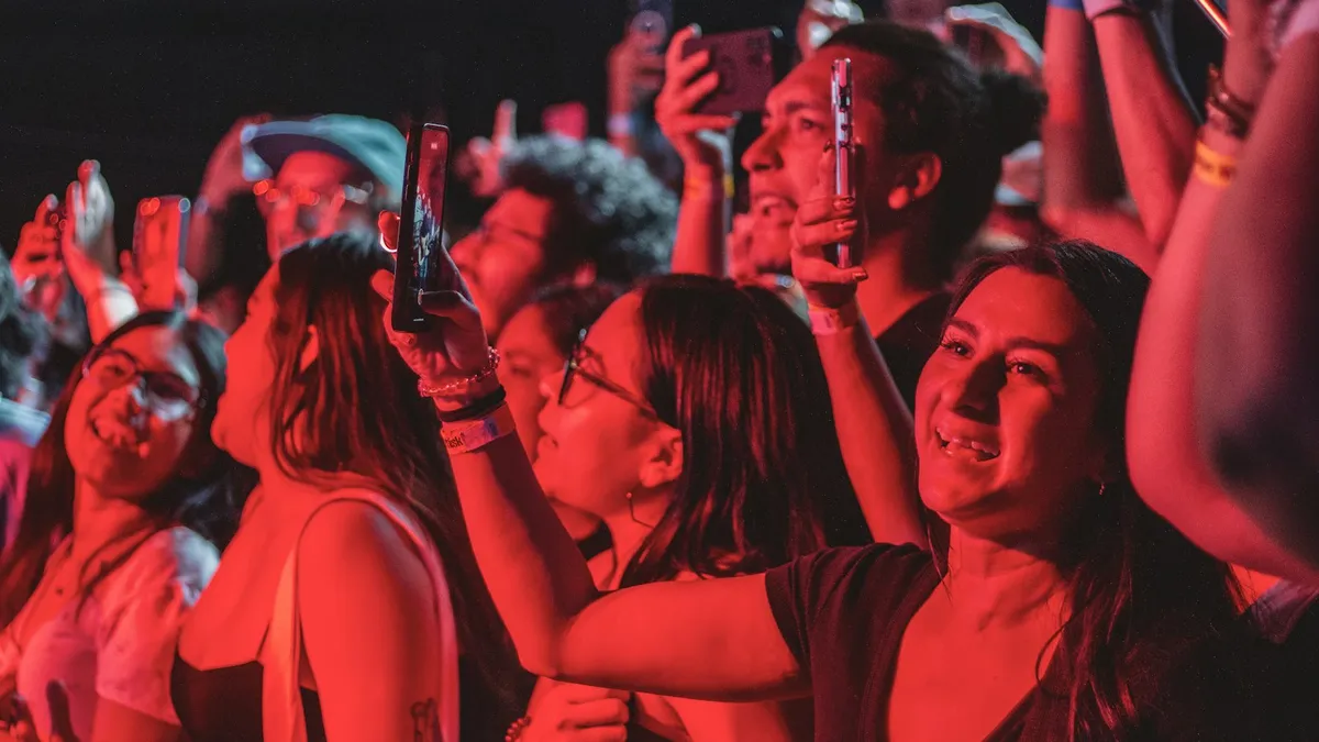 A crowd at a concert recording the stage on their phones