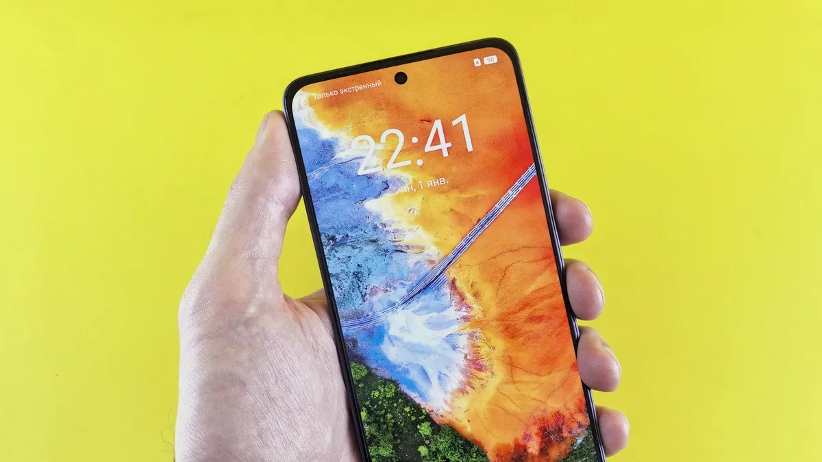 A phone held in one hand showing its lock screen