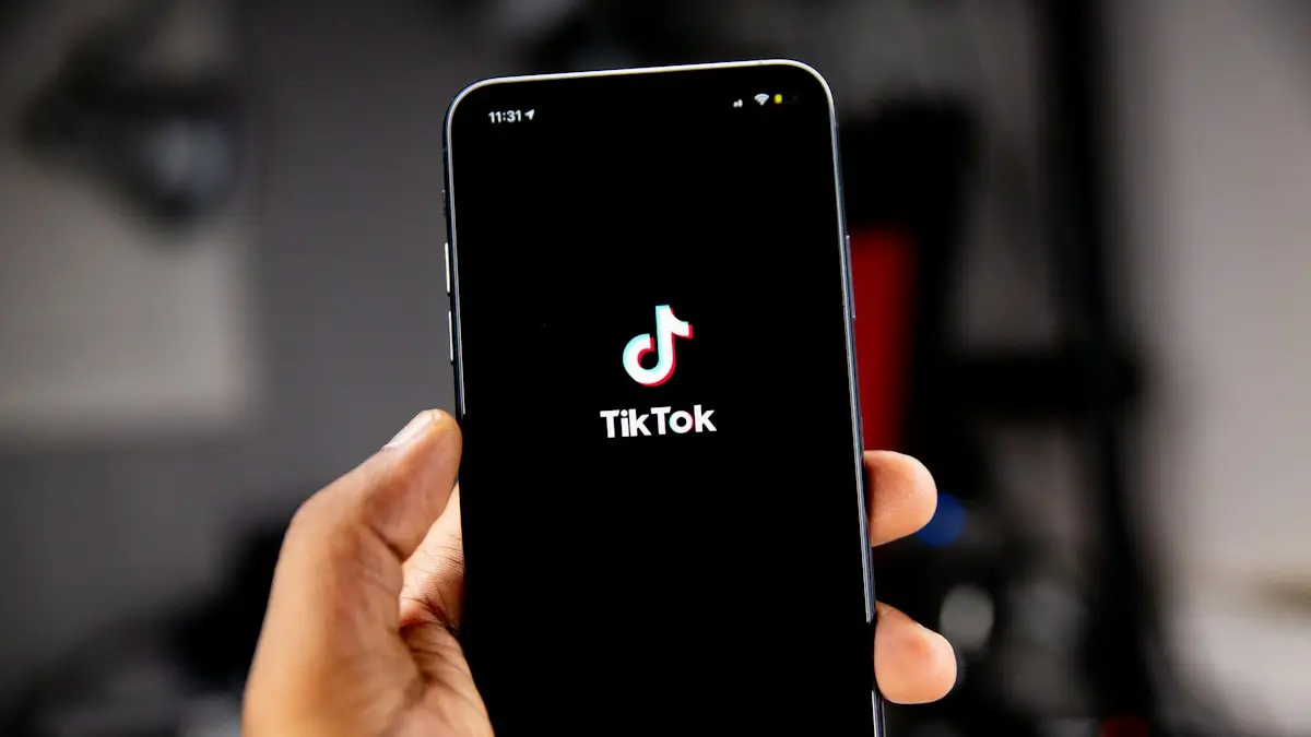A hand holding a smartphone displaying the TikTok logo on a black screen