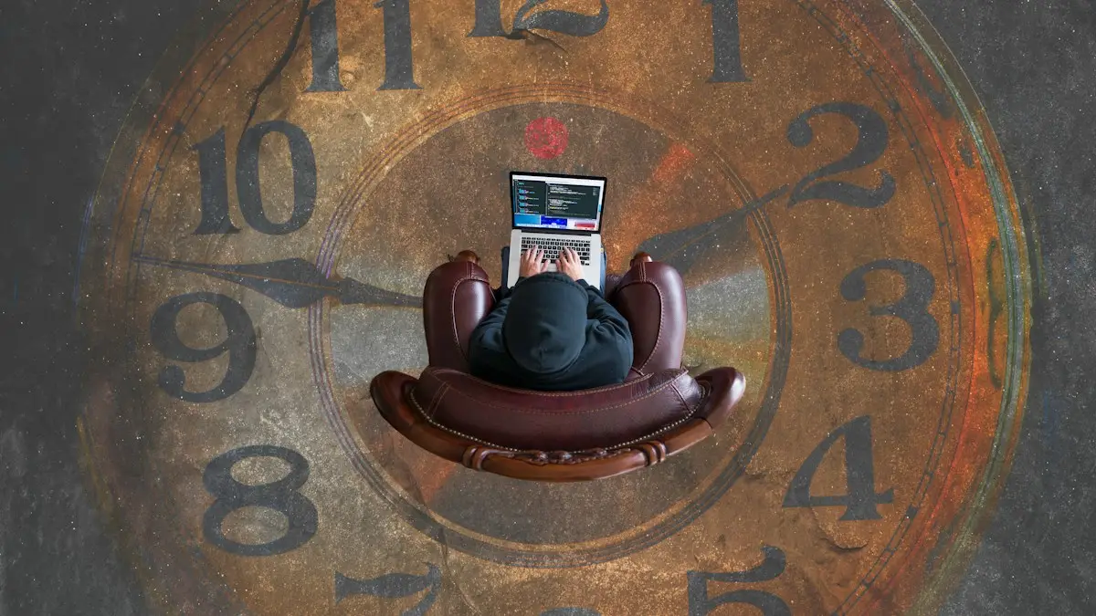 A person in a hoodie typing on a laptop in a leather armchair