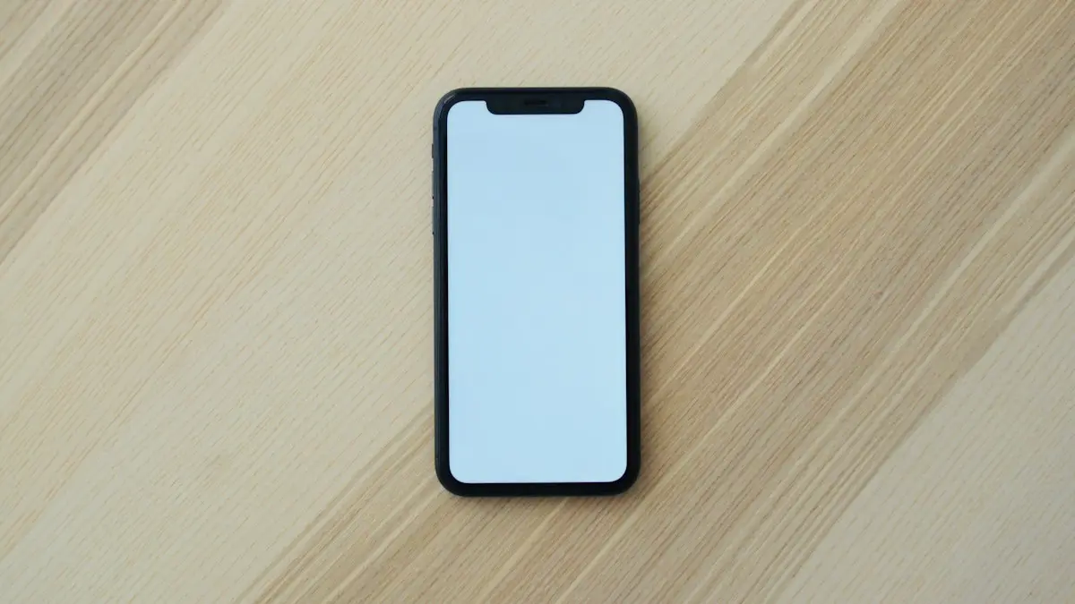 A black smartphone with a blank white screen on a light wooden surface