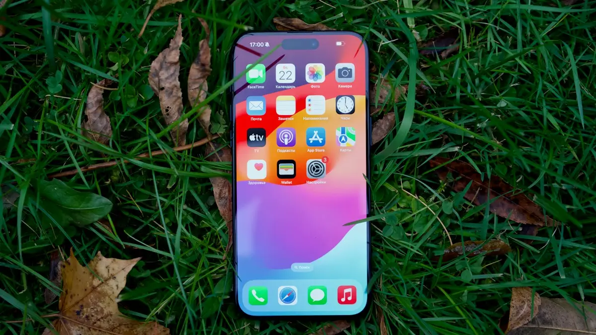 A close up of a cell phone laying in the grass