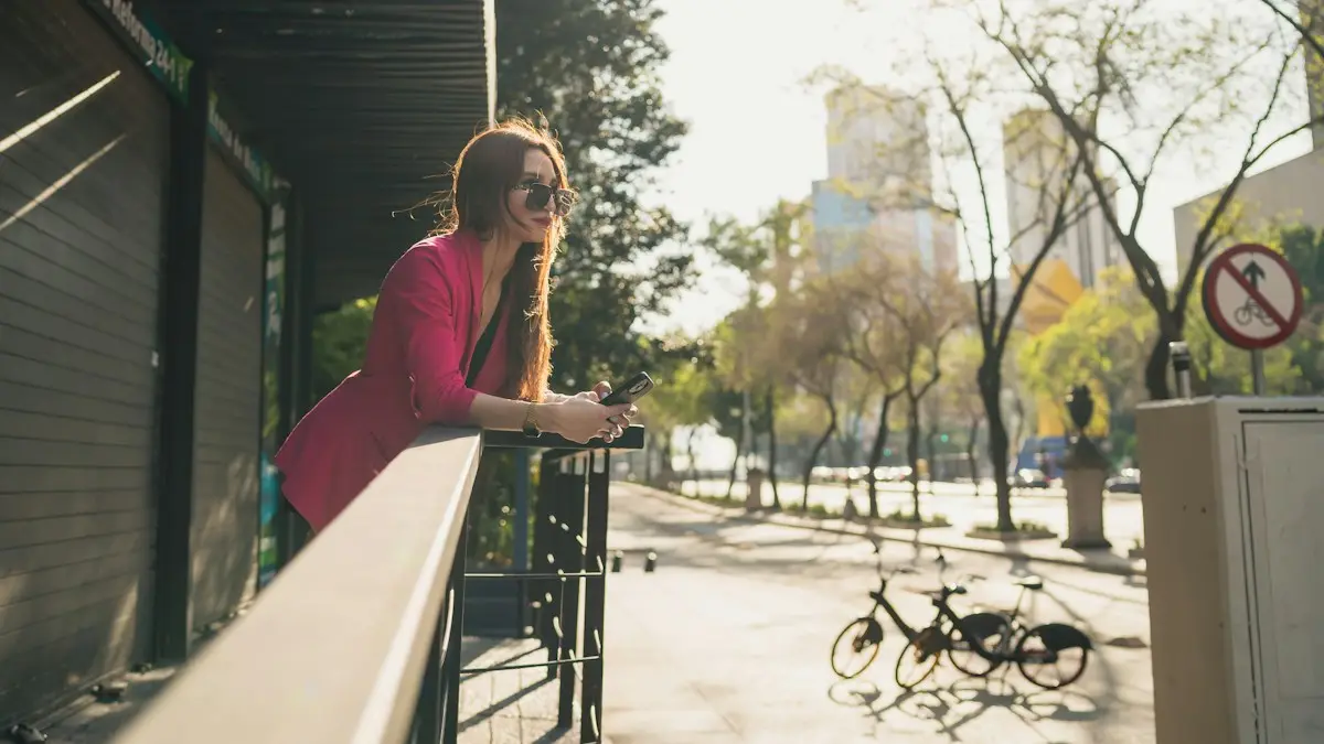 A woman leaning on a rail looking at her cell phone